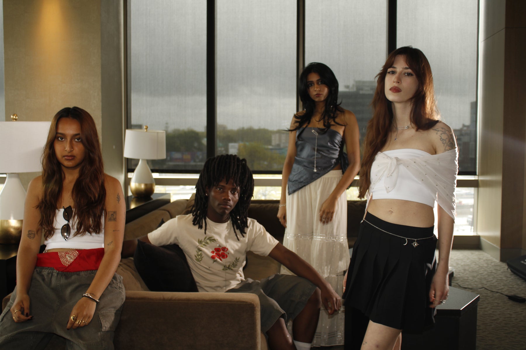 Four people in a modern living room with large windows.