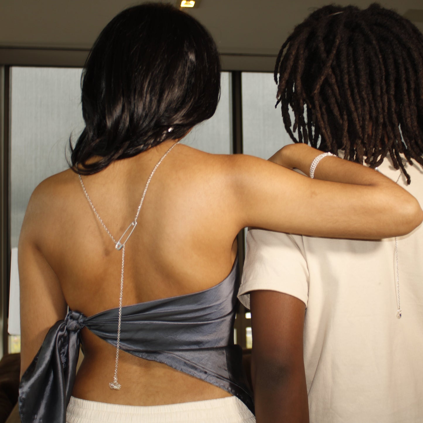 Two people standing close together with a neutral background