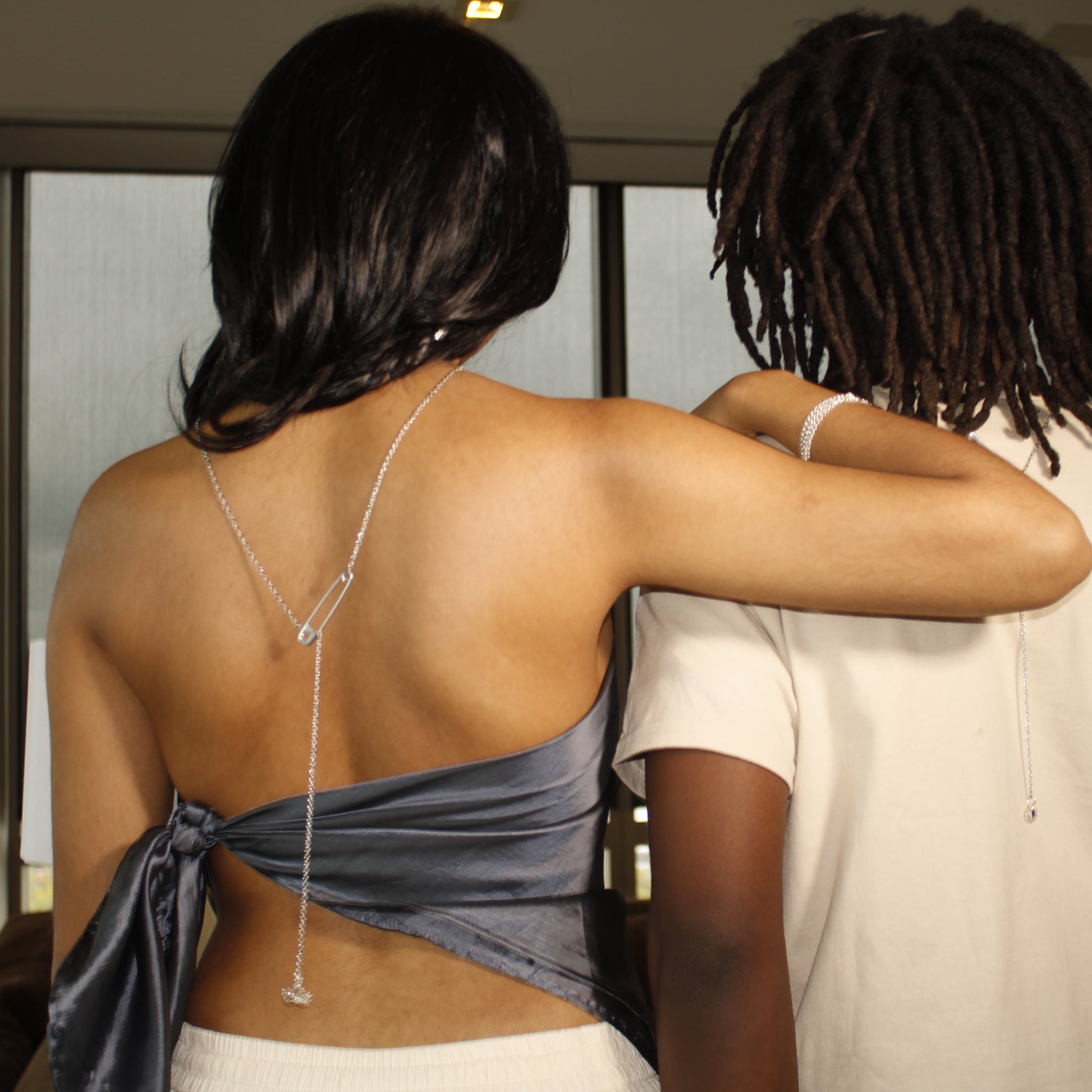 Two people standing close together with a neutral background