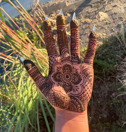 Hand with intricate henna design outdoors